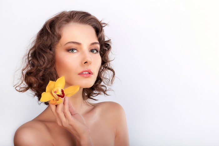 Woman with Brown Hair and Yellow Orchid