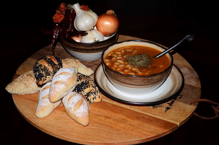 Bowl of bean soup with bread and vegetables