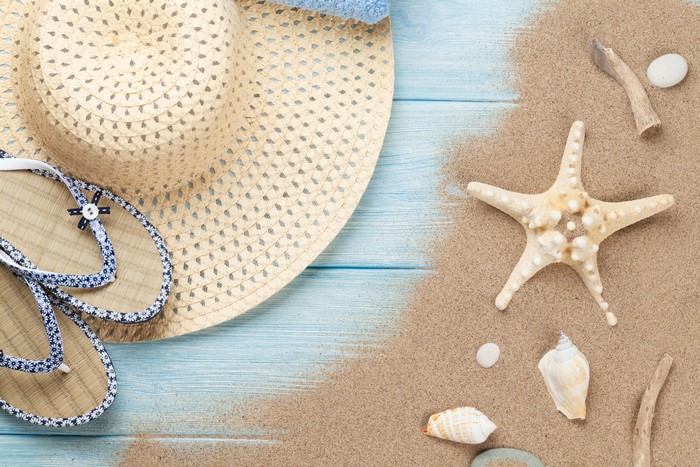 Straw hat and flip-flops on a beach