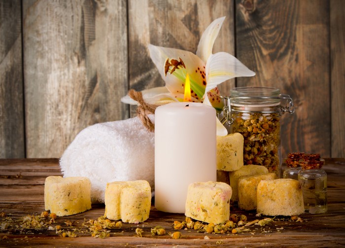 Spa items with candle, towel, and flower