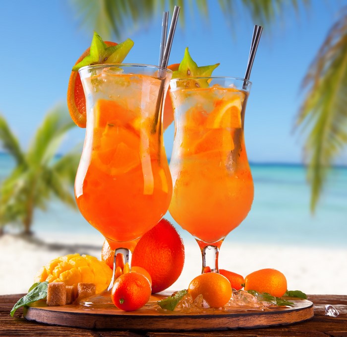 Two tropical cocktails on a beach background
