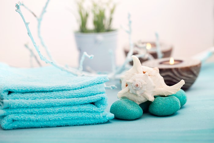 Spa setting with towels, shells, and candles
