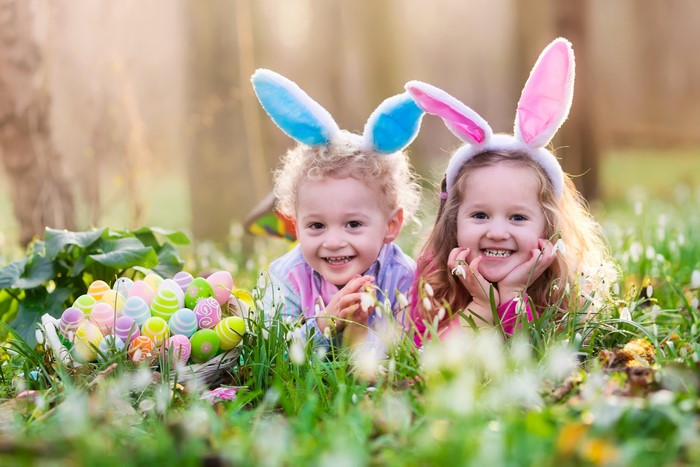 Two children with Easter bunny ears and eggs