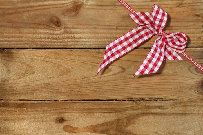 Red and white checkered bow on wood planks