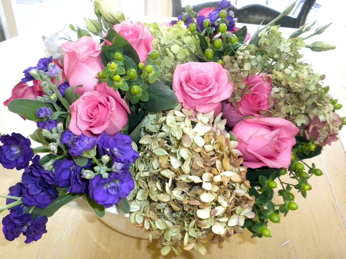 Pink roses, purple stock flowers, and hydrangeas in a bouquet