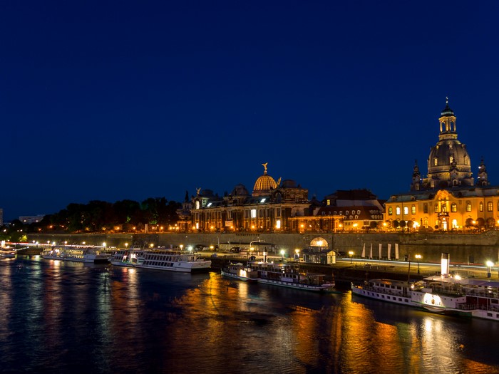 Dresden skyline with boats on the Elbe River at night