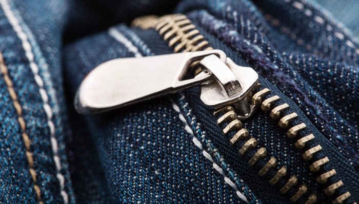 Closeup of a metal zipper on blue jeans