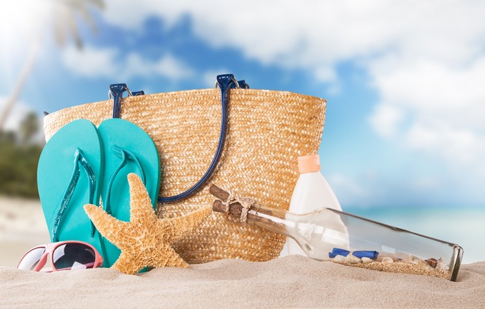 Beach accessories on sand with ocean background