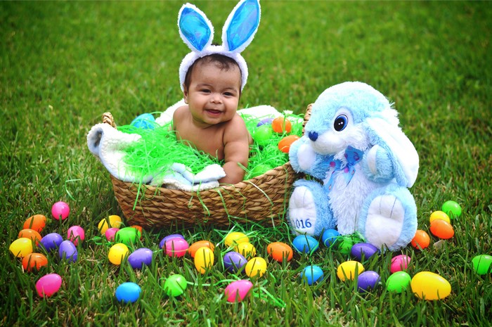 Baby in Easter basket with bunny and eggs