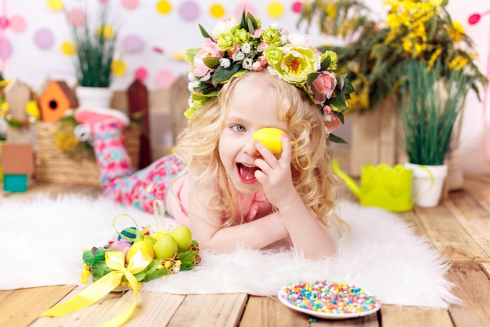 Little girl with Easter flower crown and eggs