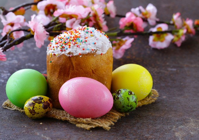 Easter Kulich with colorful eggs and pink blossoms