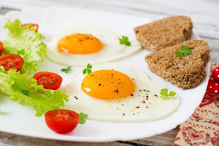 Fried eggs with cherry tomatoes, lettuce, and toast
