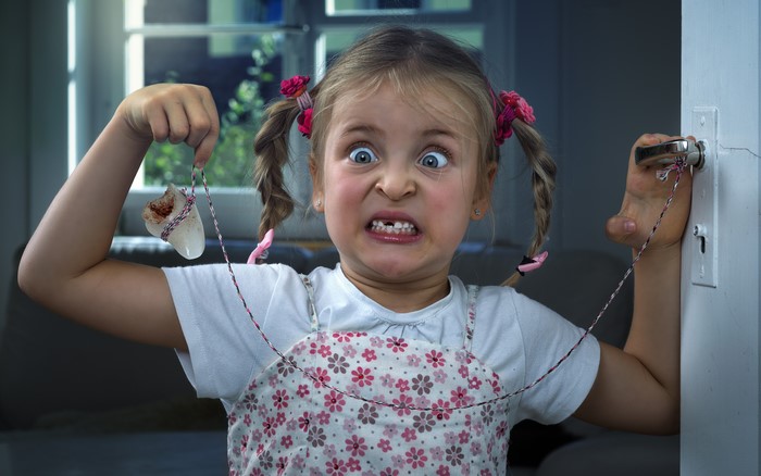 Little girl holding a tooth