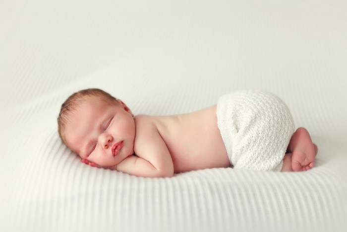 Newborn baby sleeping on white blanket