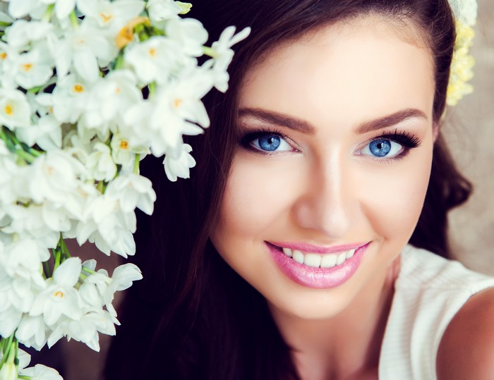 Woman with blue eyes and white flowers