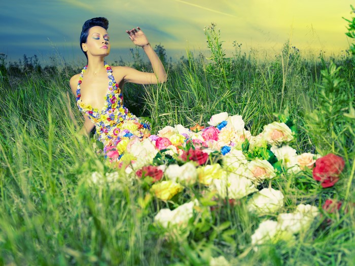 Woman in flower dress sitting in grass