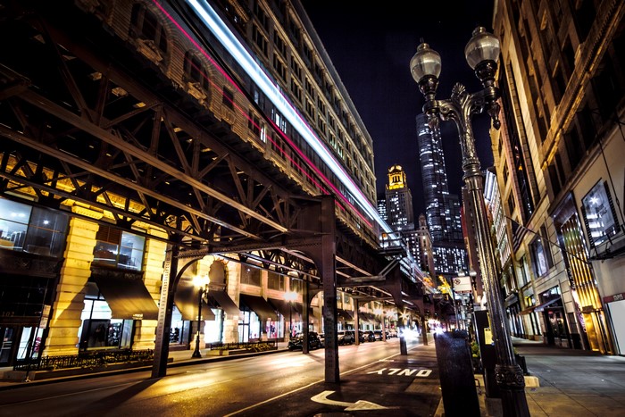 Night view of elevated train tracks and street lights in Chicago