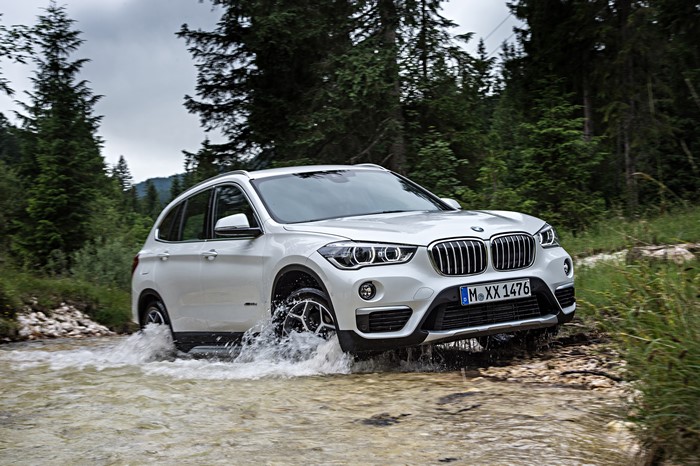 White BMW X1 xDrive xLine F48 driving through water