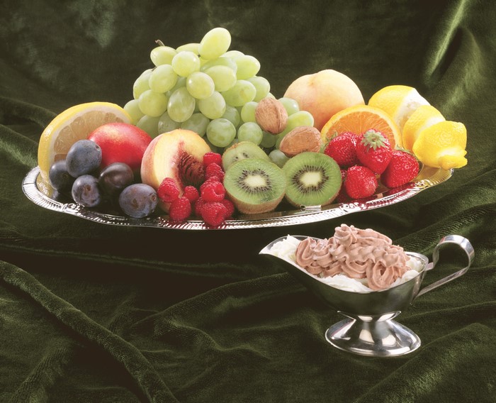 Fruit platter with grapes, kiwi, strawberries, and dessert