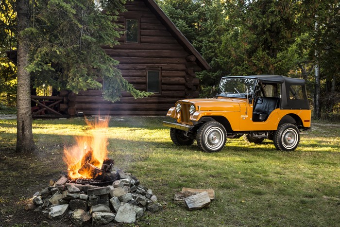 Orange Jeep CJ-5 by Log Cabin with Campfire