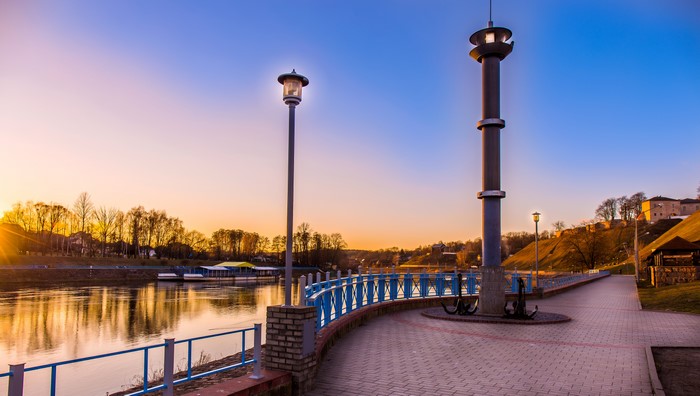 Grodno, Belarus riverfront with lighthouse and street lights at sunset