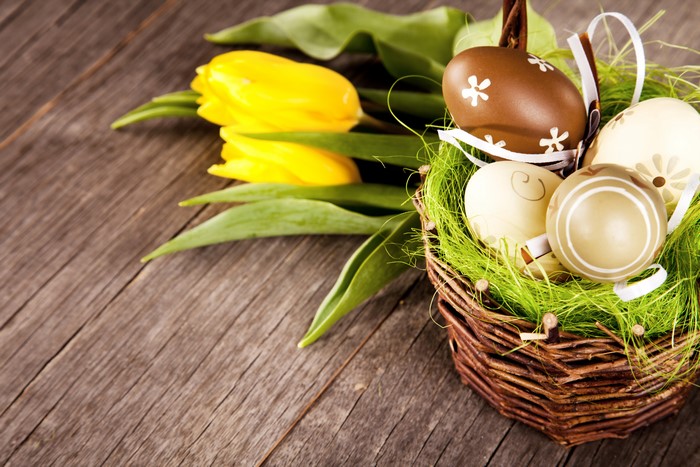 Easter eggs and yellow tulips in a wicker basket