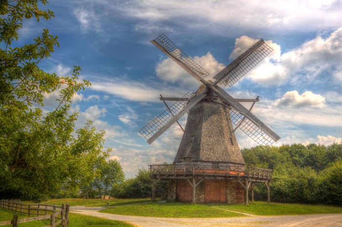 Windmill with wooden balcony against a cloudy sky