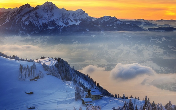 Snowy mountains at sunset with a lodge