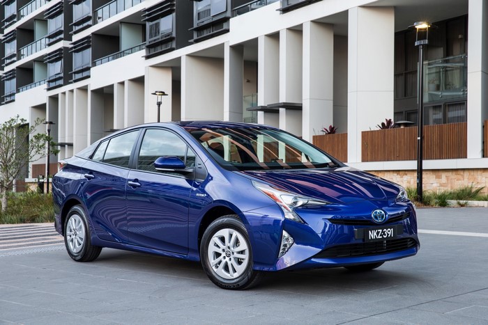 Blue 2016 Toyota Prius parked in front of a modern building