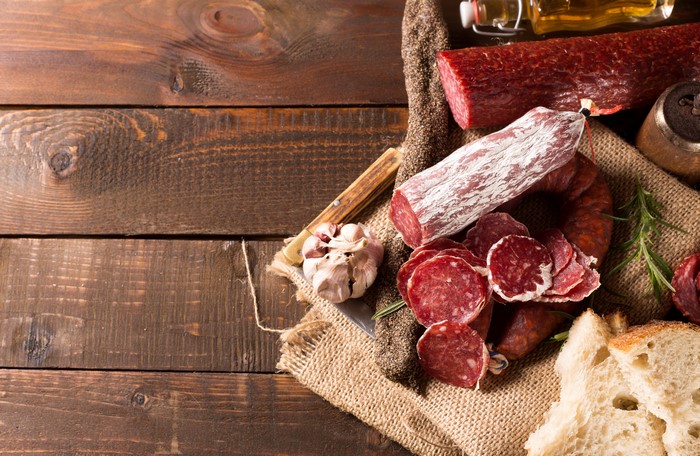 Assortment of cured meats and garlic on a wooden table