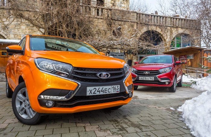 Two Lada XRAY cars parked outside a stone building