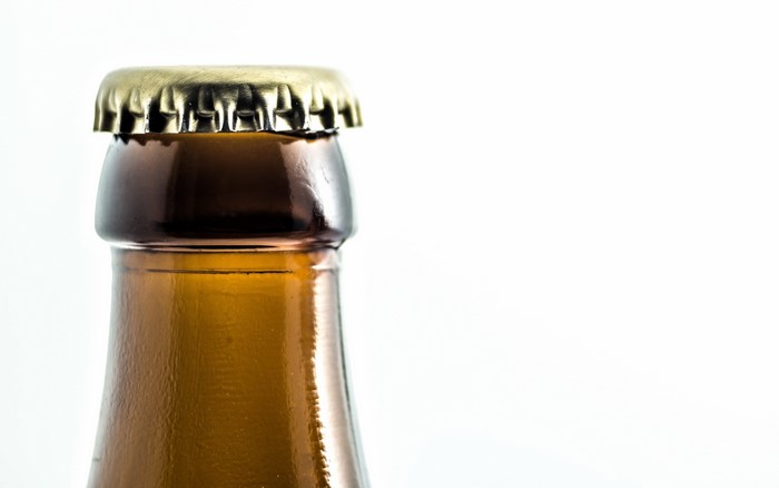 Closeup of a brown glass bottle with a metal cap