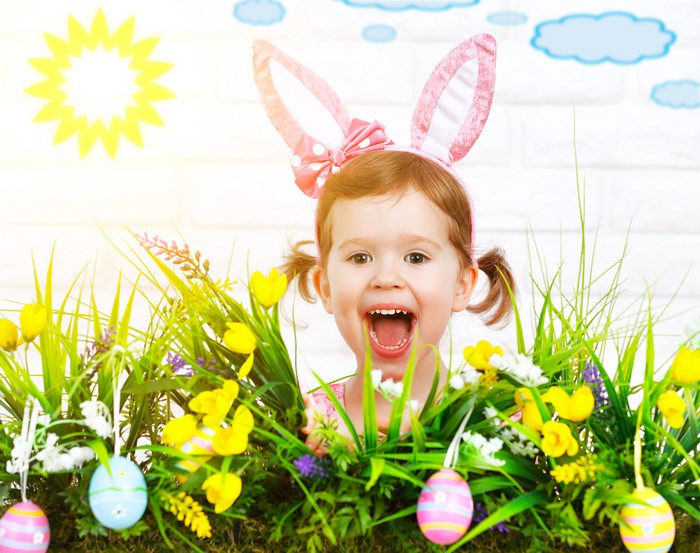 Little girl with Easter bunny ears and eggs