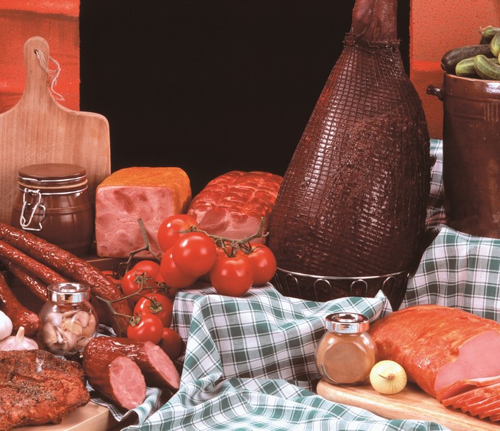 Assortment of cured meats, tomatoes, and pickles