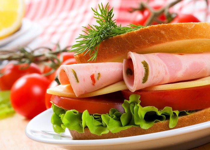 Sandwich with ham, cheese, lettuce, tomato, and dill