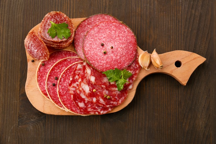 Sliced salami and garlic on a wooden board