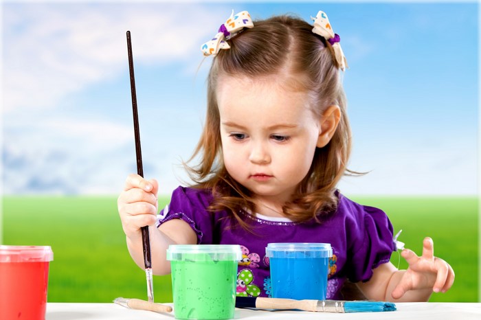 Little girl painting with colorful paints
