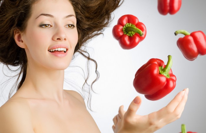 Woman with brown hair and red bell peppers