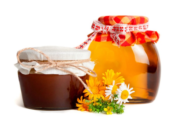 Two jars of honey with flowers