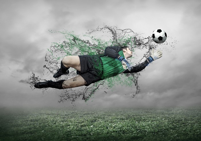 Goalkeeper jumping for a football