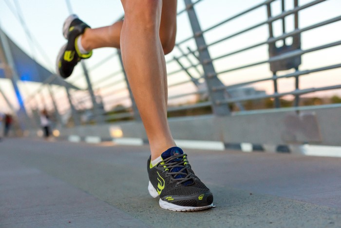 Runner's Legs and Athletic Shoes on a Bridge