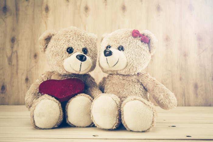 Two teddy bears with a heart