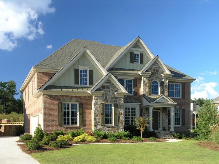 Brick and stone mansion with a green lawn