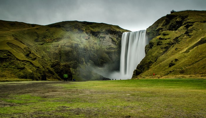 Skogafoss Waterfall in Iceland with green mossy cliffs