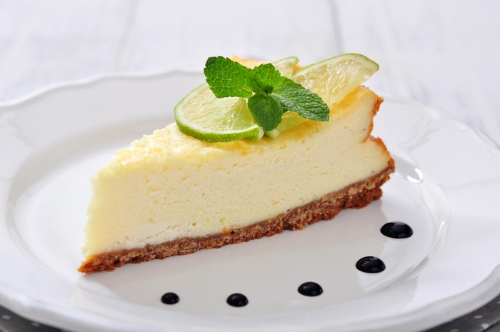 Slice of lime cheesecake with mint and lime slices