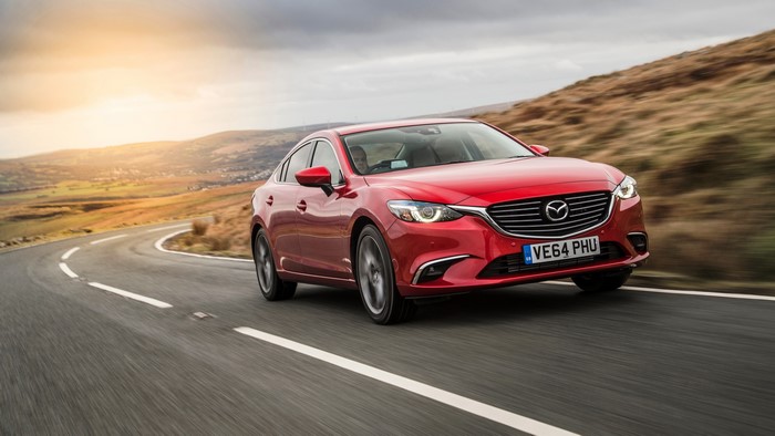 Red Mazda 6 Sedan driving on a winding road