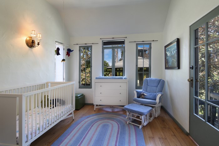 Nursery room with crib, changing table, and glider