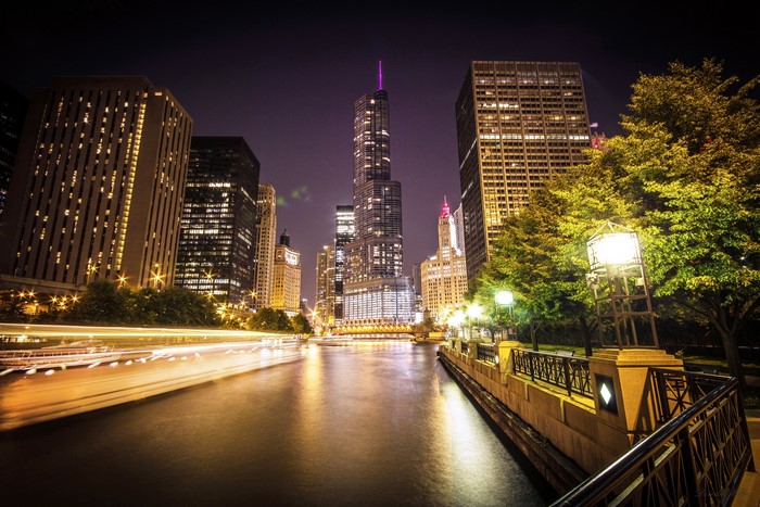 Chicago city skyline at night with river and boat