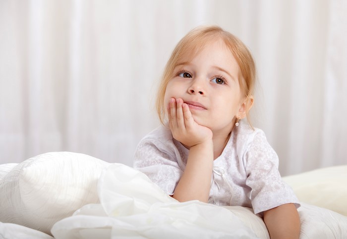 Little girl with blonde hair looking up