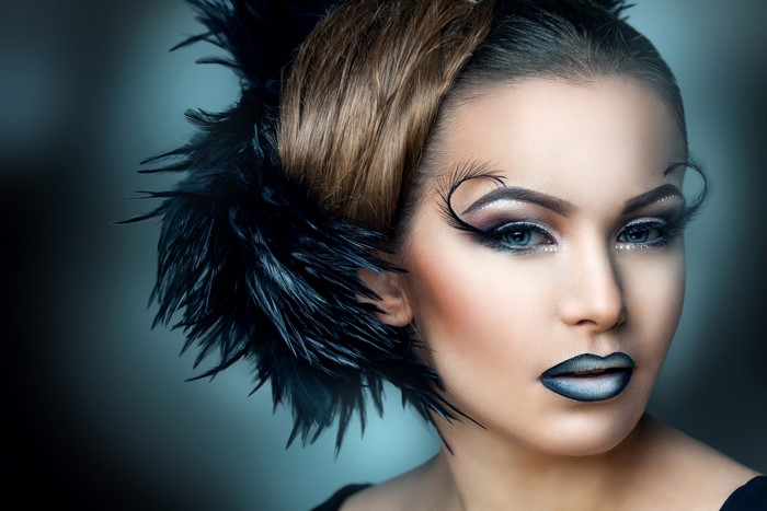 Woman with dramatic makeup and black feathers